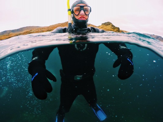 Split-view of snorkeler on hot spring tour in Kleifarvatn, Iceland