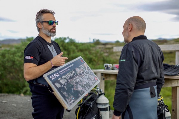 DIVE.IS guide telling snorkeler all about Silfra in Iceland