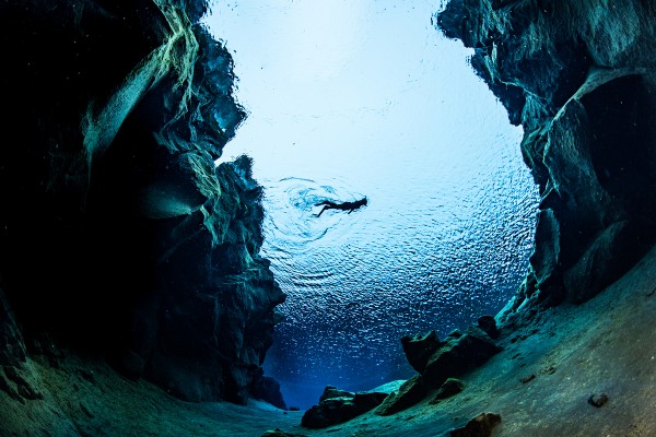 Fish eye image of a snorkeler swimming between the Continents in Silfra